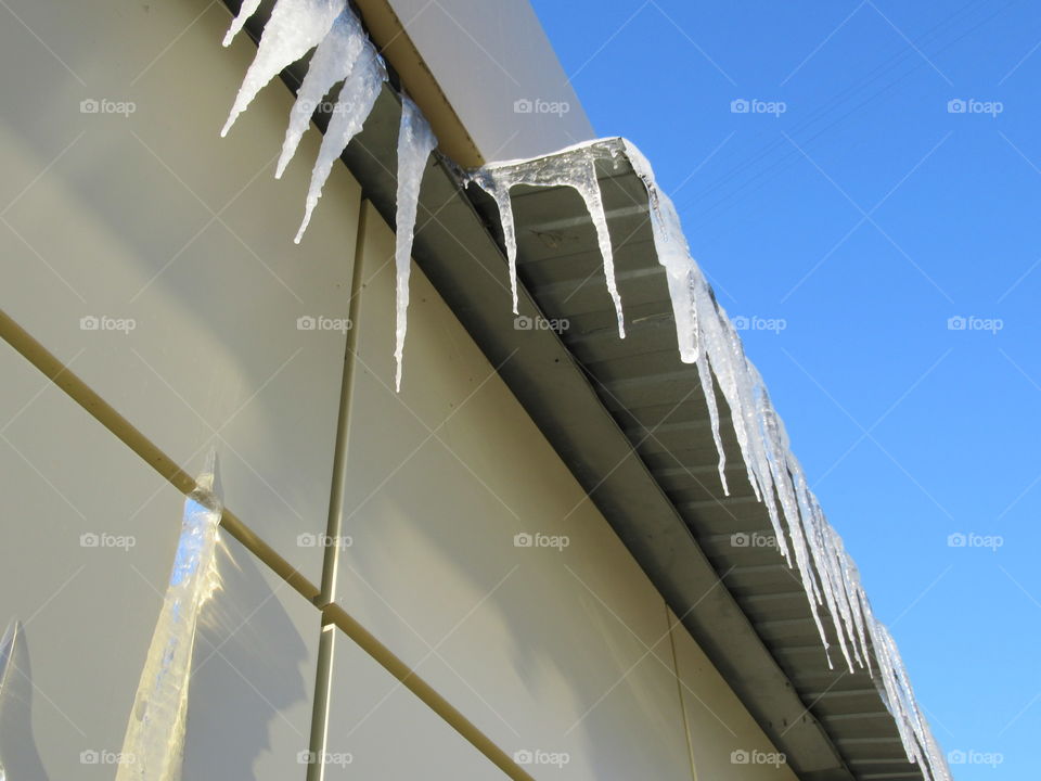ice icicles on the cornice in the sun, harbingers of spring