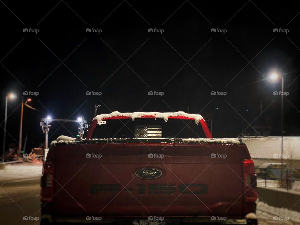 American flag displayed in the rear window of a pickup truck