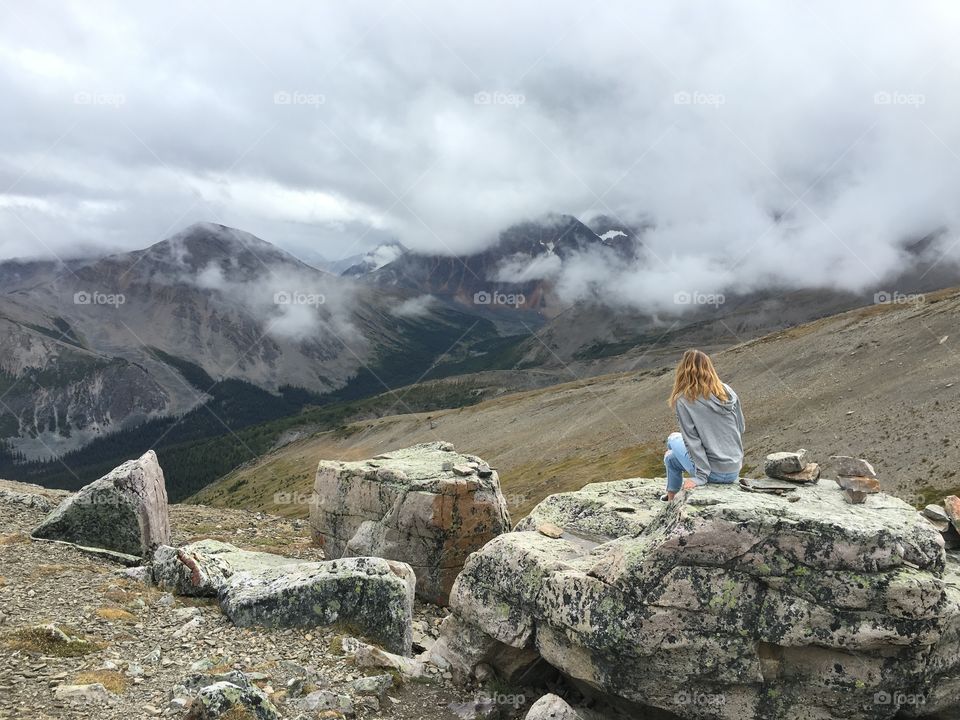 Sitting alone amongst the clouds on the top of a mountain 