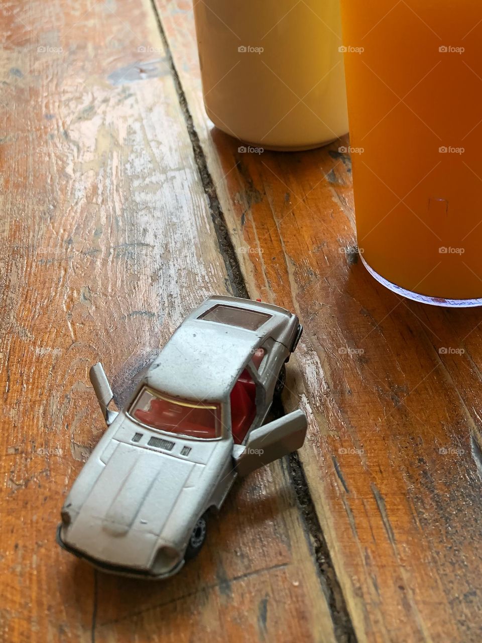 1/10 scale model of Datsun 240z on table with orange juices 