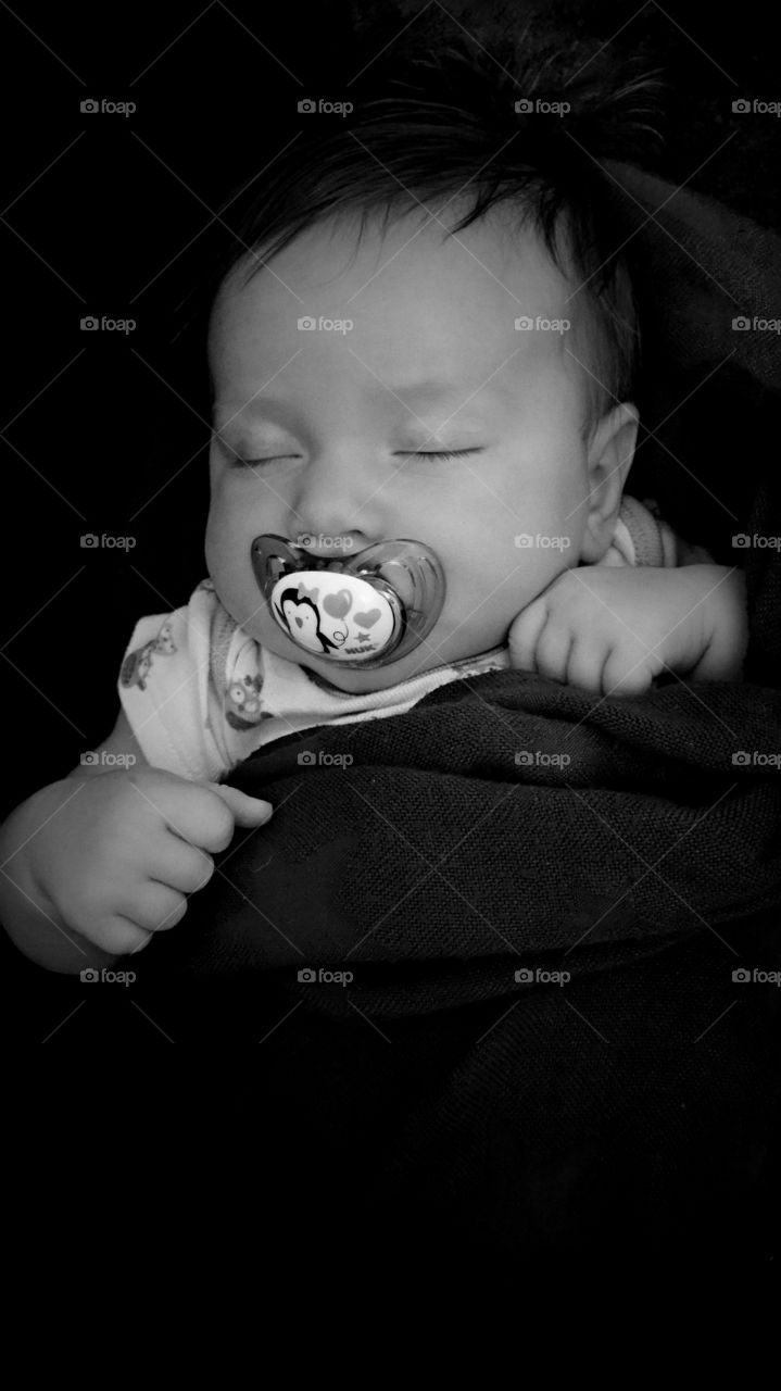 Elevated view of a boy sleeping with soother in his mouth