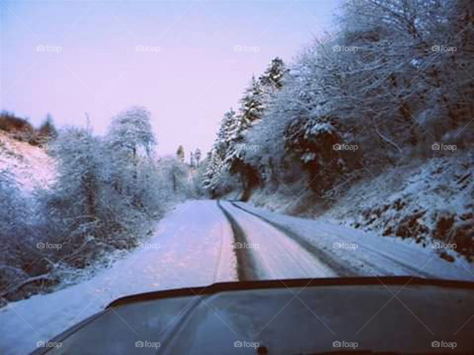 driving on mountain road in the snow in winter