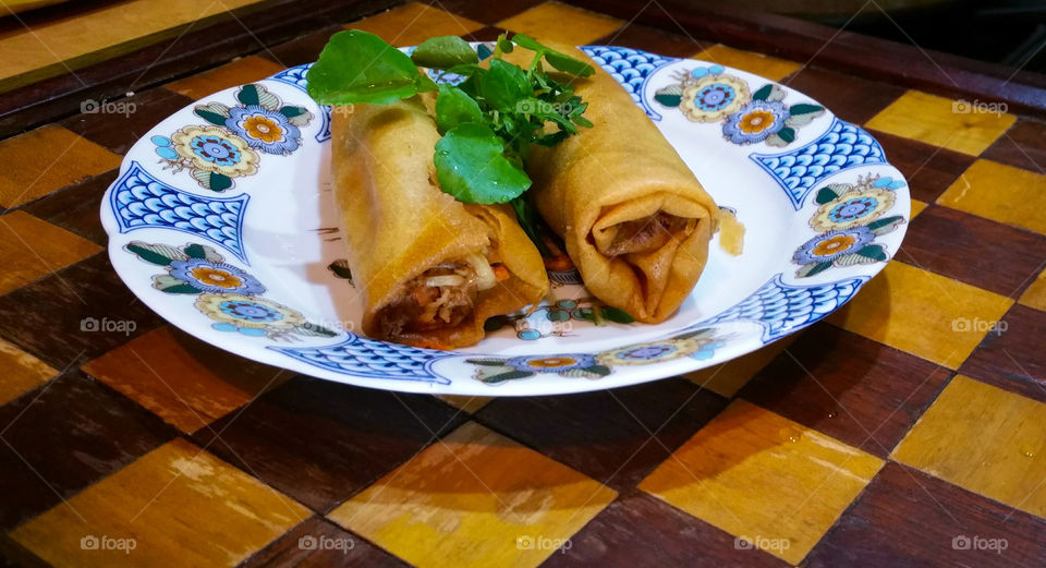 A Couple of Spring Rolls with some green leaves