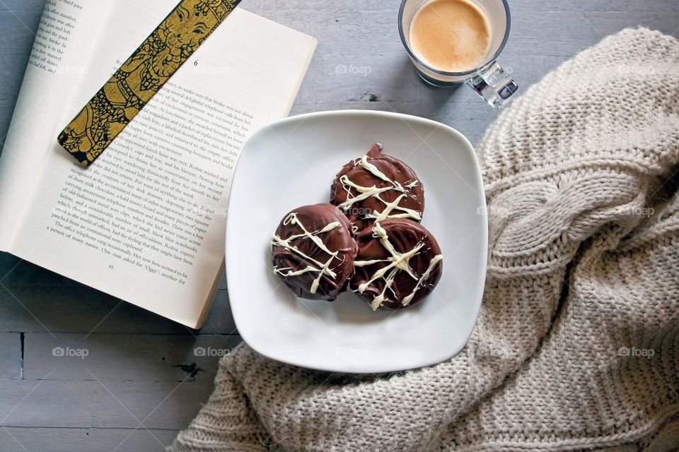 Chocolate biscuits served on a white plate with espresso coffee on the side and a good book.