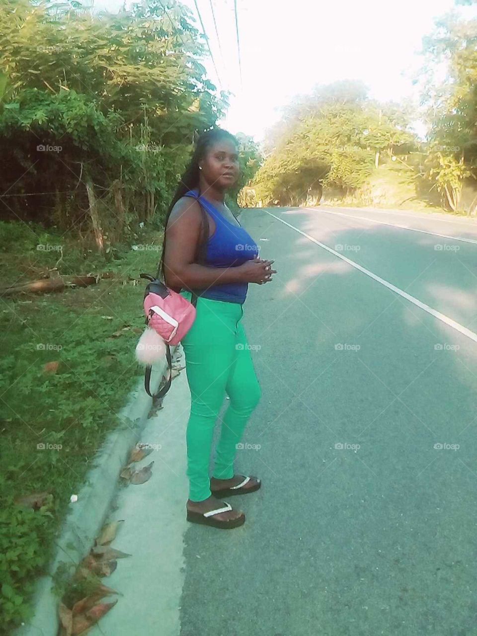 well as you can see this beautiful woman  is standing on the the side of the road and waiting for a cab.