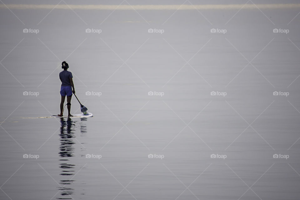 Tourists on surf boards in the sea at Prachuap Bay in Thailand.