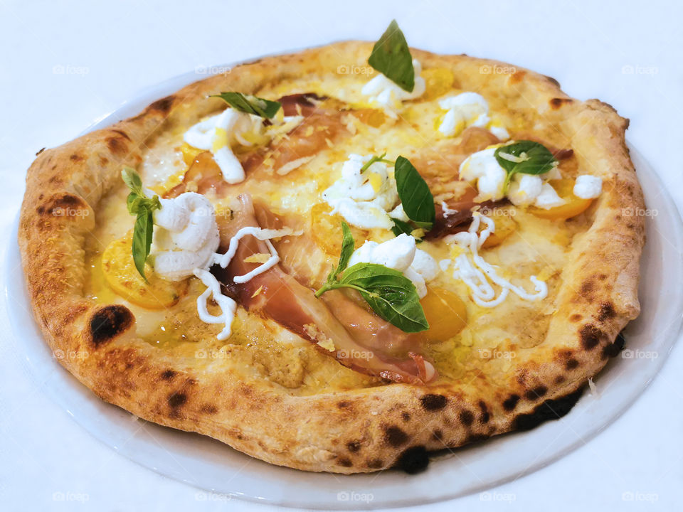 Italian pizza in a white plate.