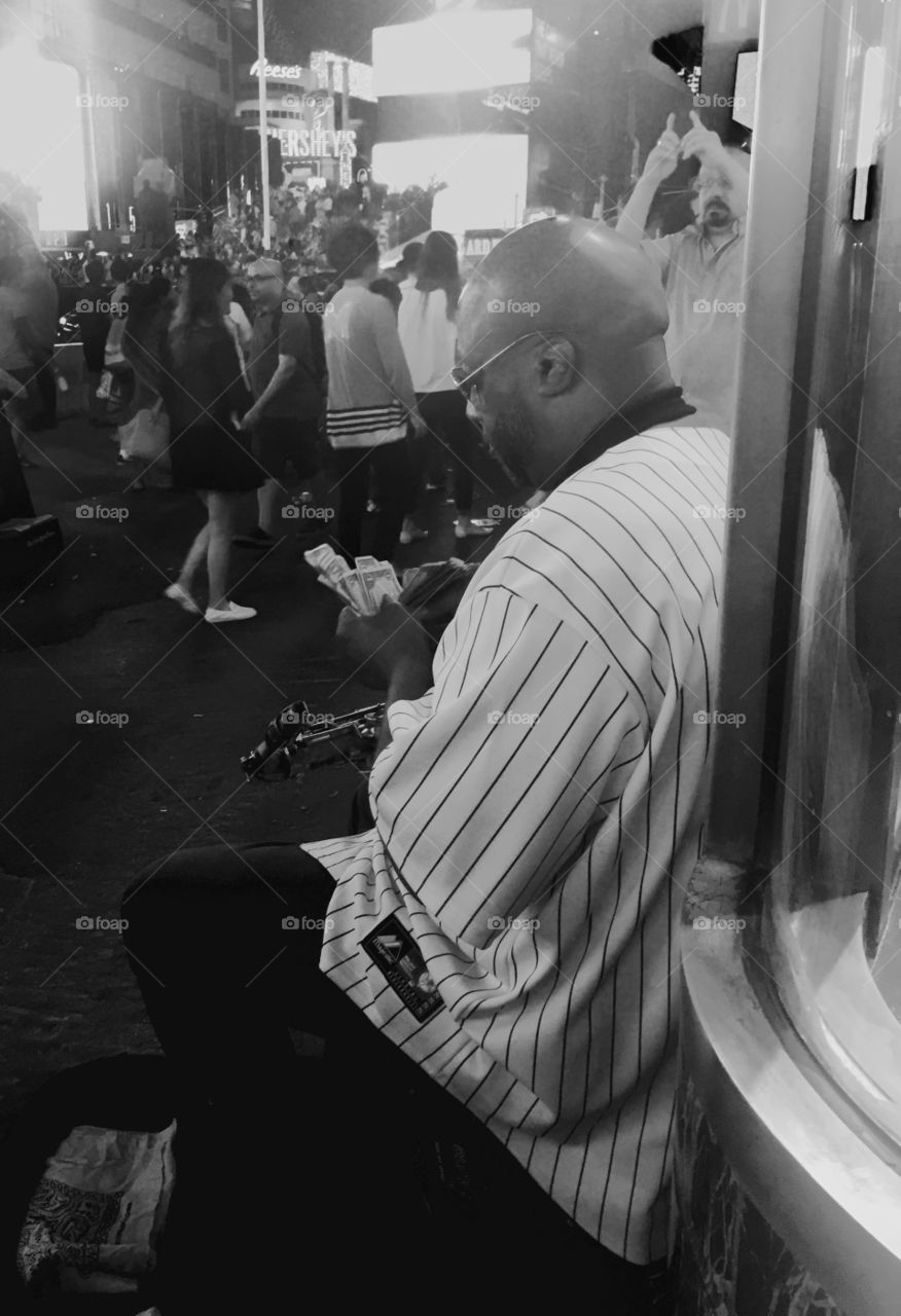 Musician counting the money in a street of New York near Times Square