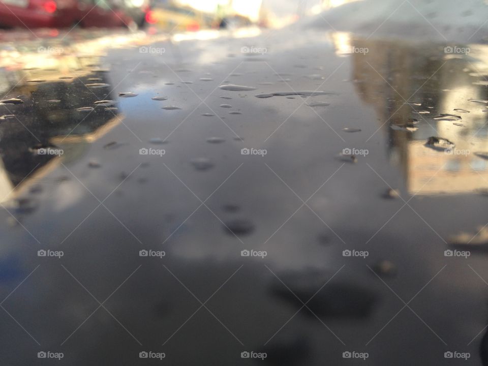 Water on BMW car with reflection of city 