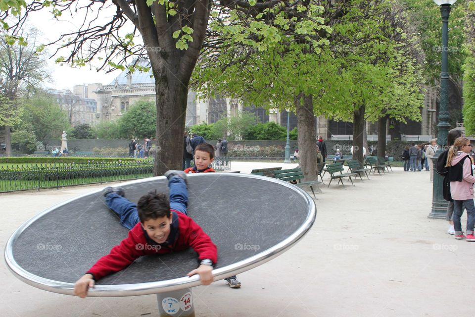 Boys/ kids playing in Cathedral Notre Dame park, Square Jean XXIII. Outdoor activities. International travel with kids.