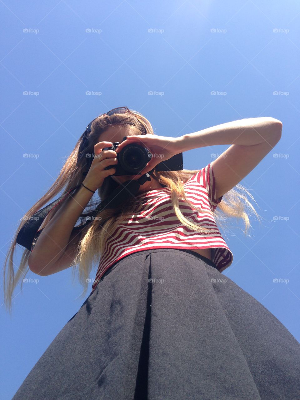 Low angle view of woman holding camera