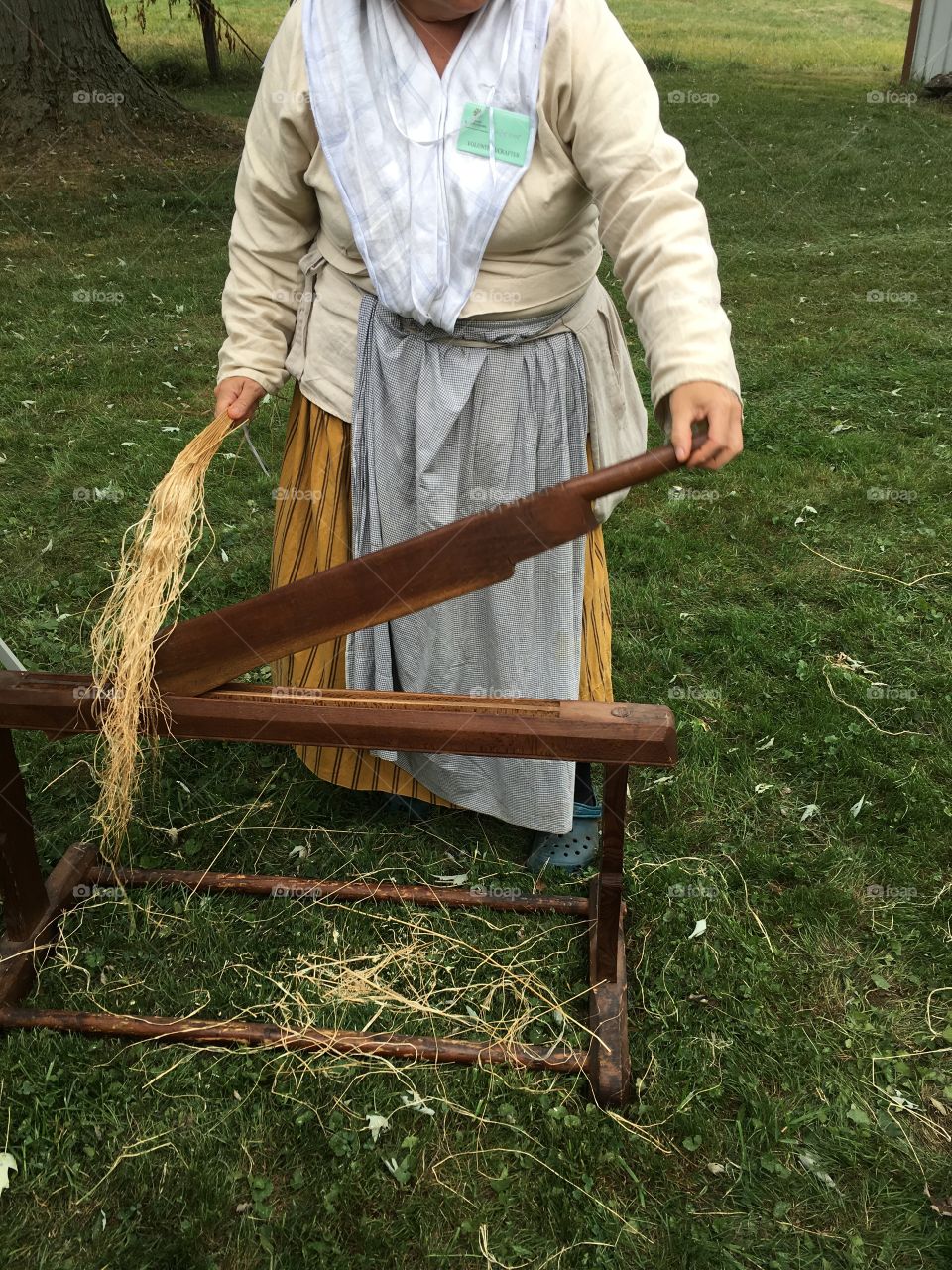 A volunteer, demonstrating the process of flax twine, sisal rope, and slave clothing during colonial times. 