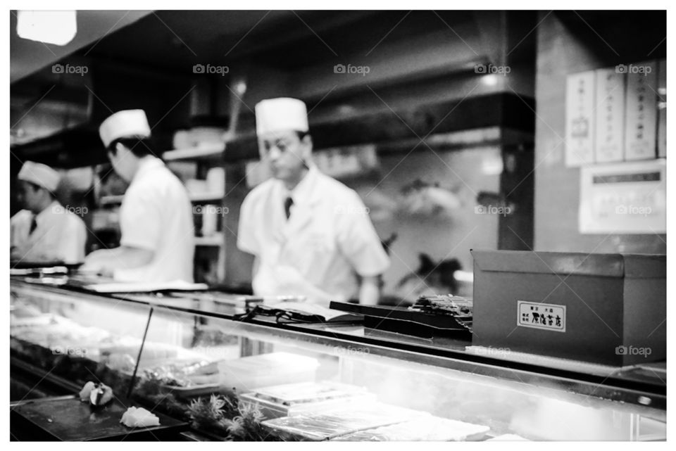 Sushi chef behind sushi bar 