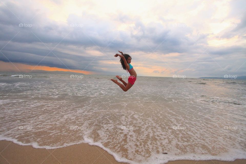 Girl jumping at the beach