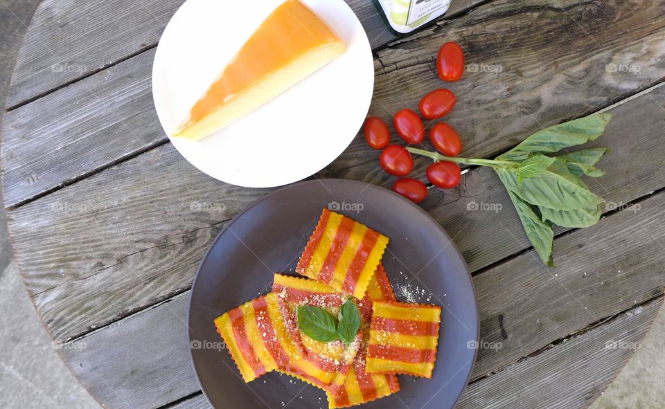 still life with ravioli, parmesan gouda cheese, tomatoes, basil