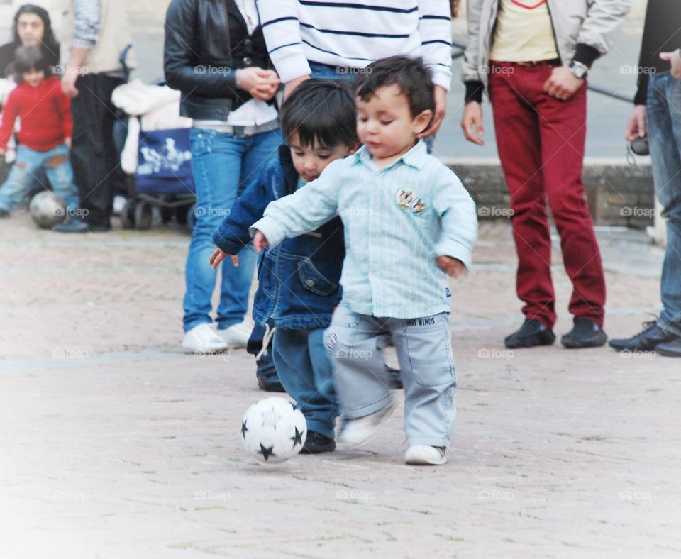 I got it!. Two toddler boys practice soccer and the village Square