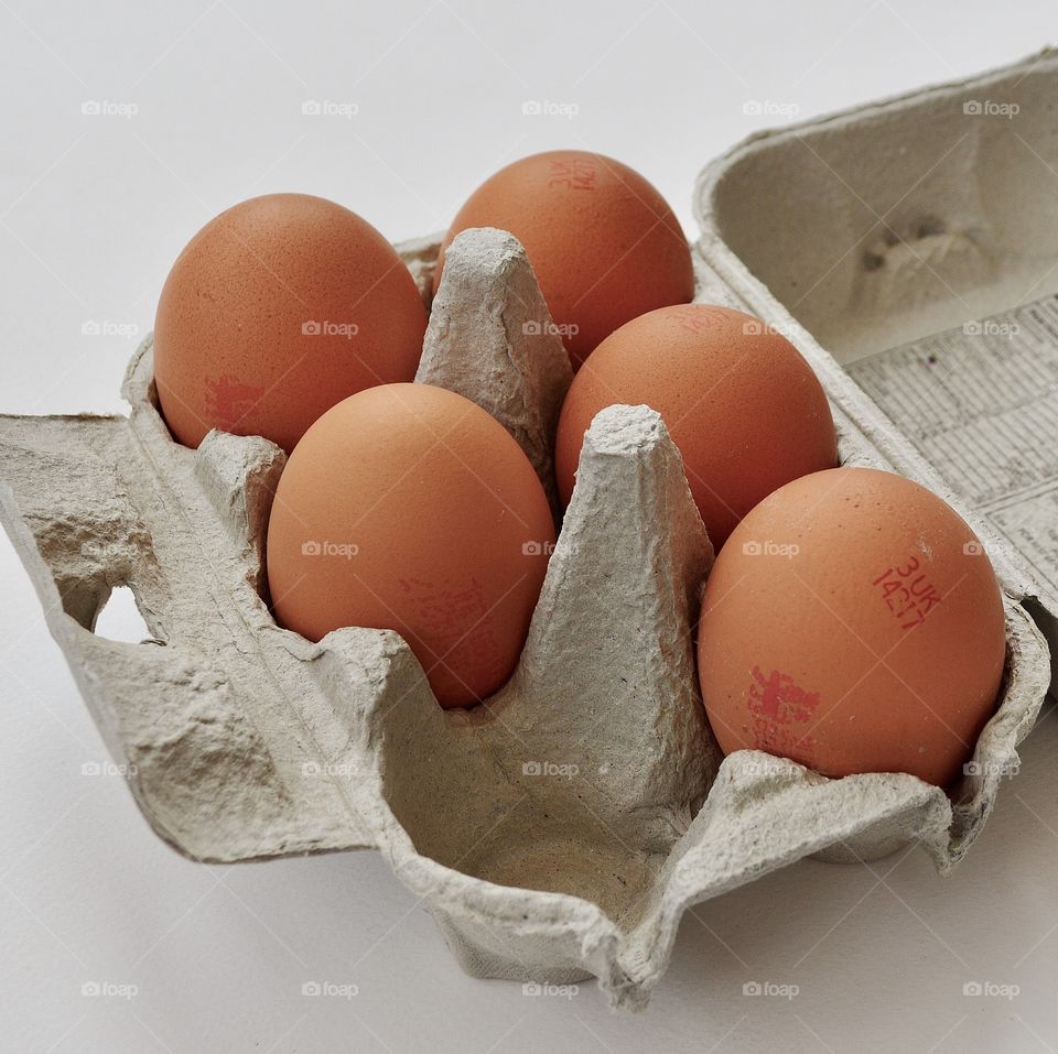 Five eggs in a cardboard egg box.