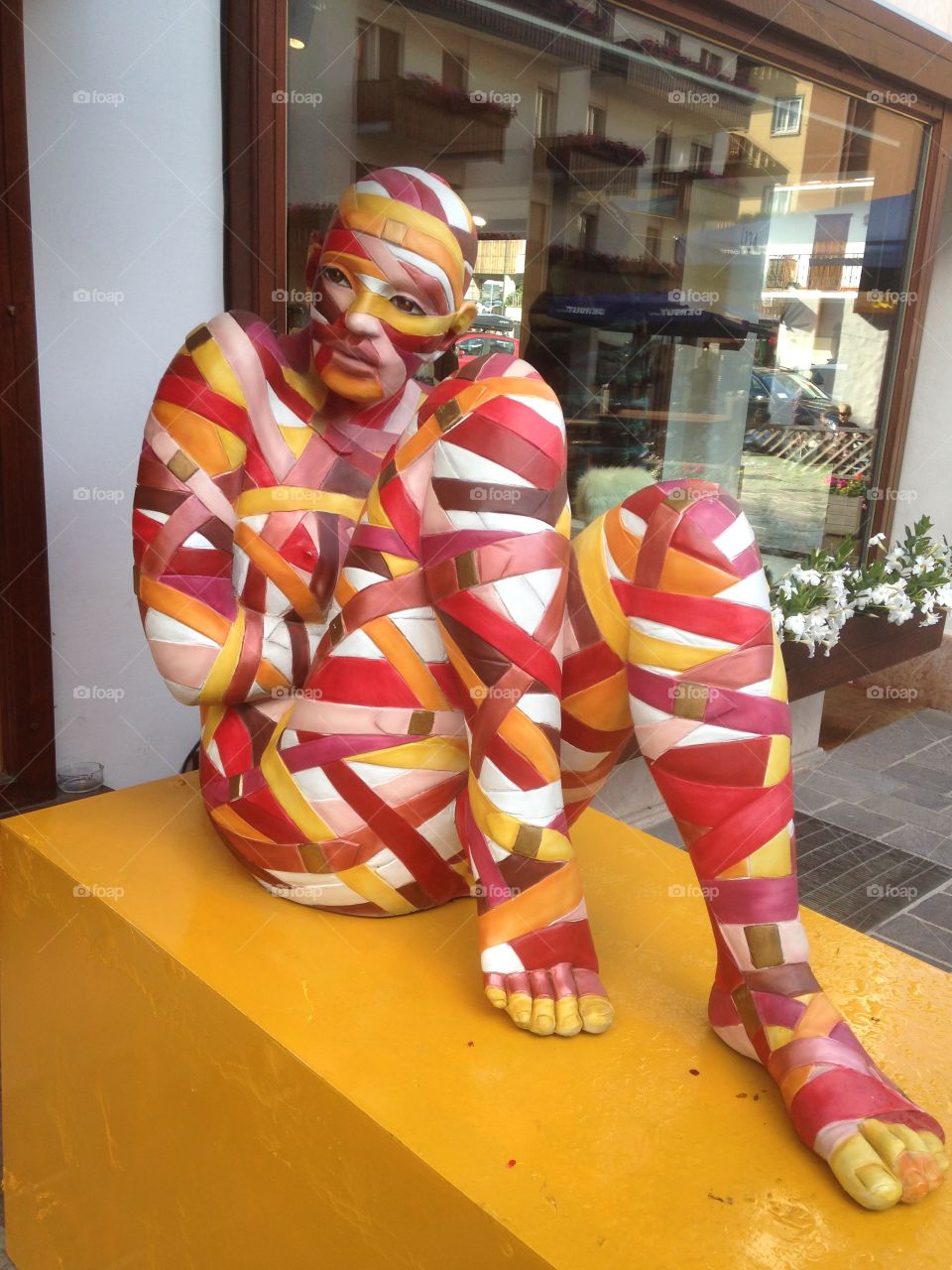 Colorful wrapped person sitting on bench