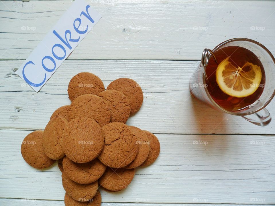 A cup of tea with lemon and oatmeal cookies