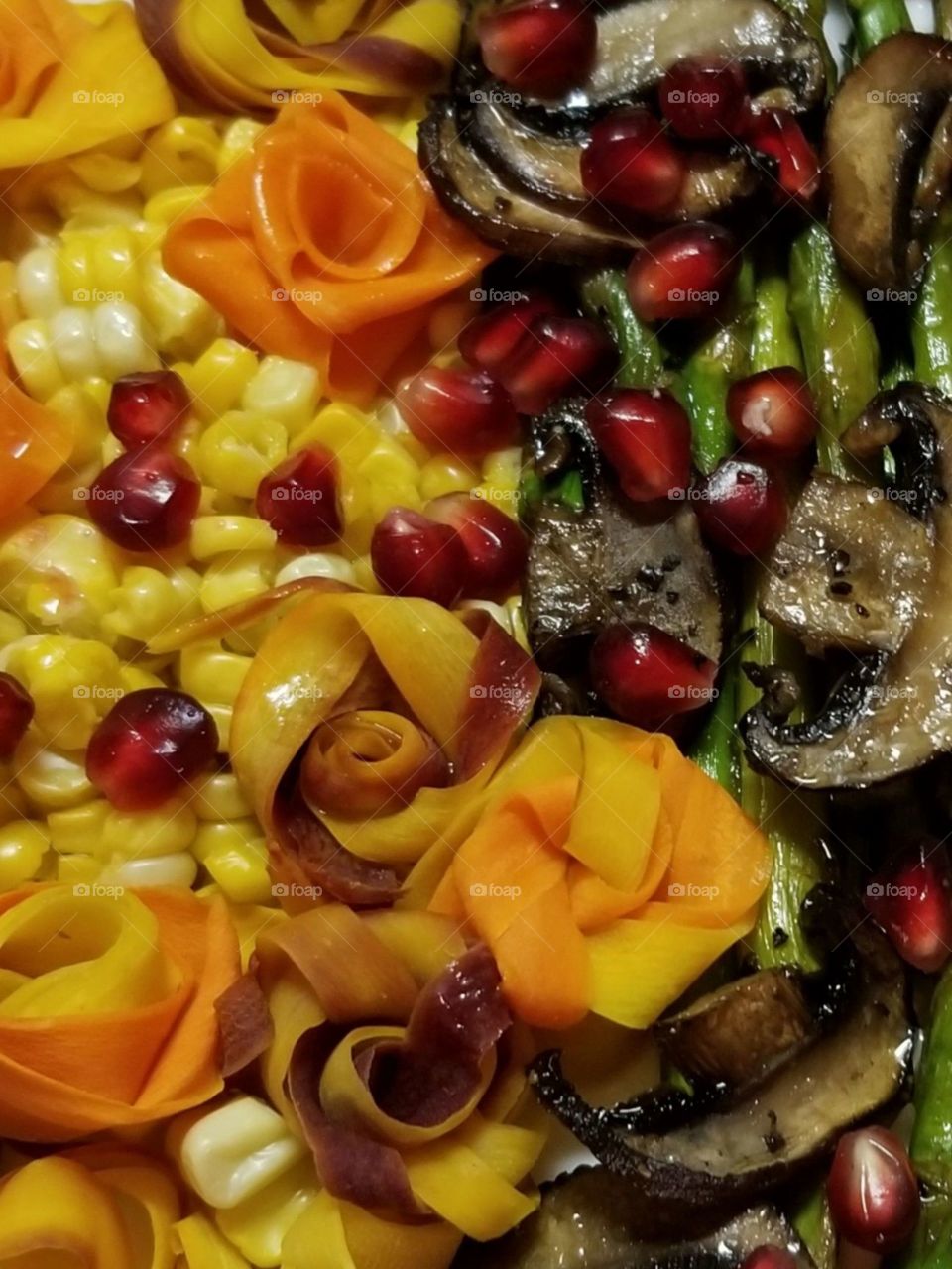 The spectacular jewel tones of the Autumn harvest are celebrated in this delicious plate. The folded roses and flowers in the fall tones are made with multi color carrot ribbons. Corn and pomegranate arils are a reflection of the colors of the fall sugar maple foliage.
