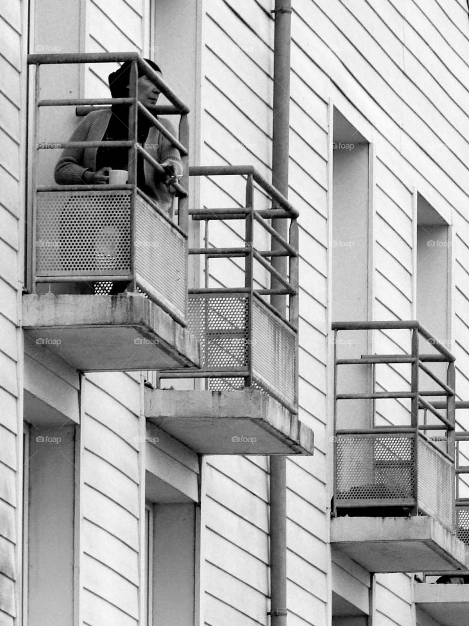 Balcony overlooking the sea or locked up like a prisoner? Black and white reinforces the feeling of solitude