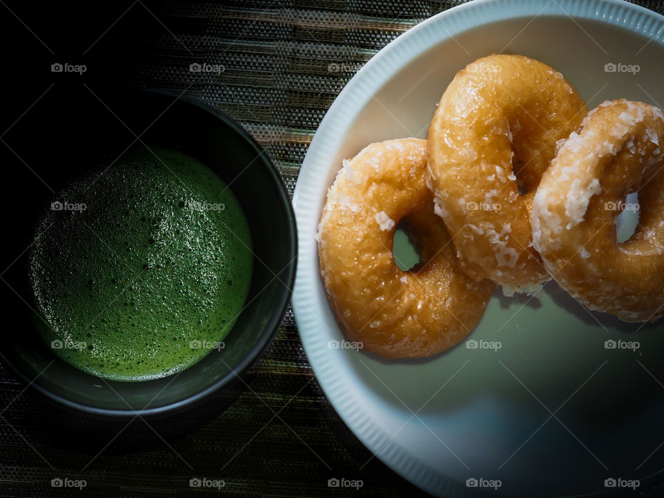 Matcha green tea drunk with soft doughnuts in the rainy morning 