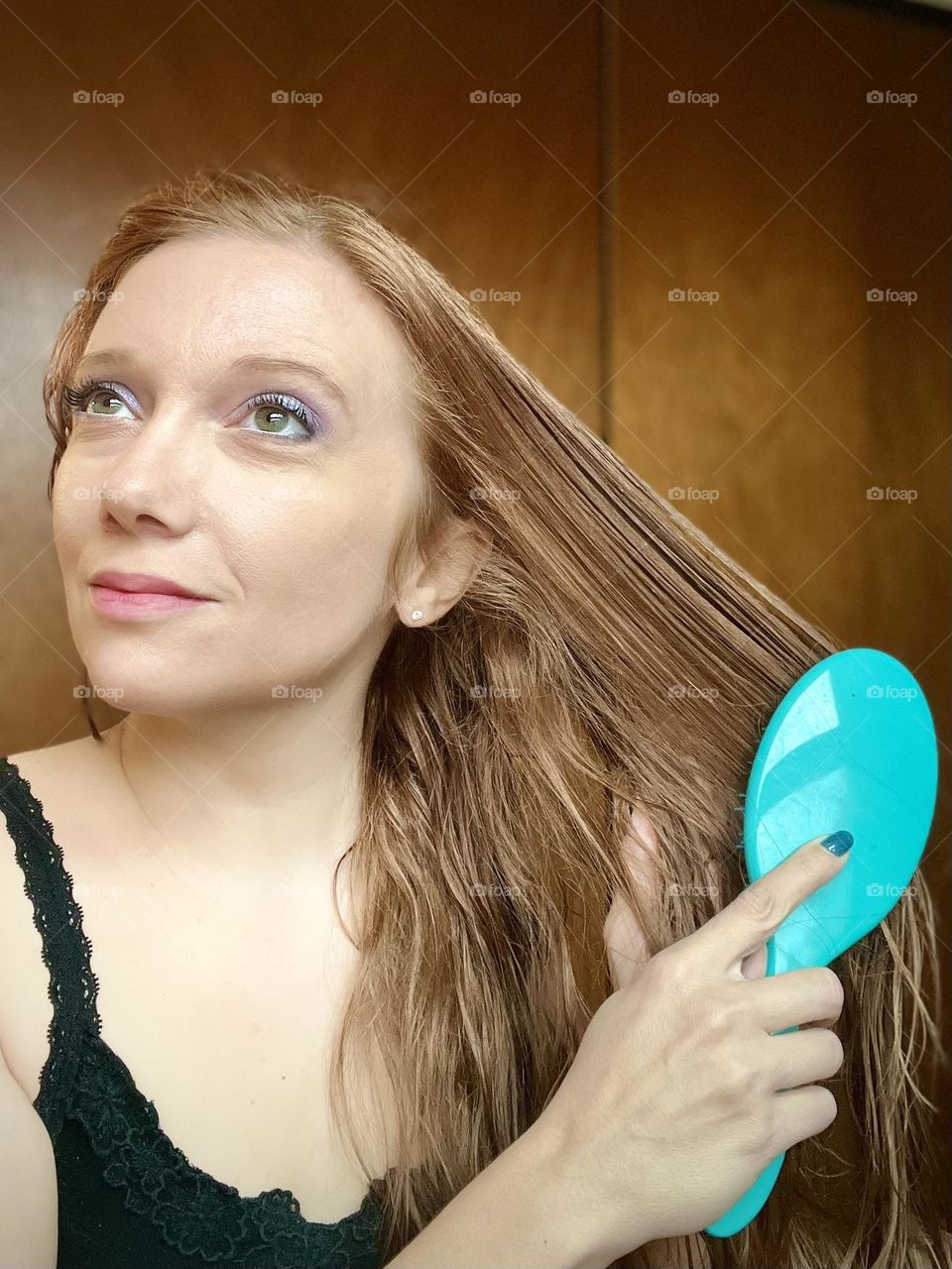 Brushing long light brown hair 