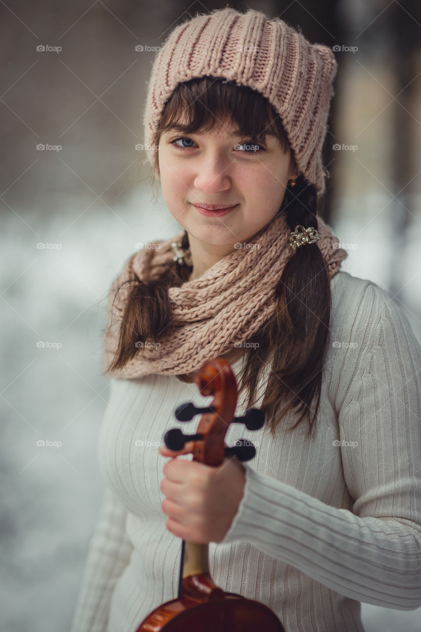 Teenage girl portrait with violin in winter park