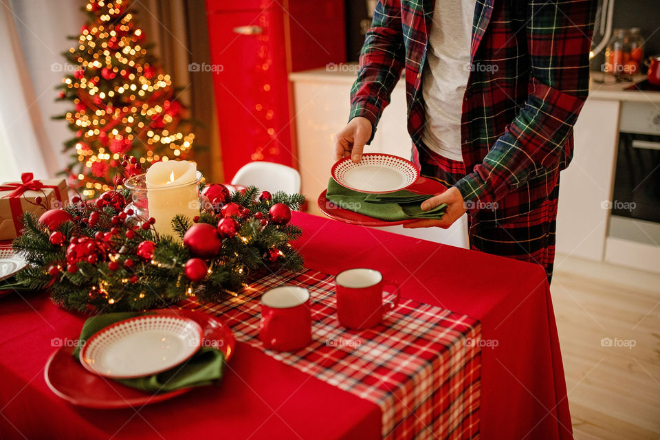 man sets a beautiful decorated winter table for a festive dinner.  Merry Christmas and Happy New Year.