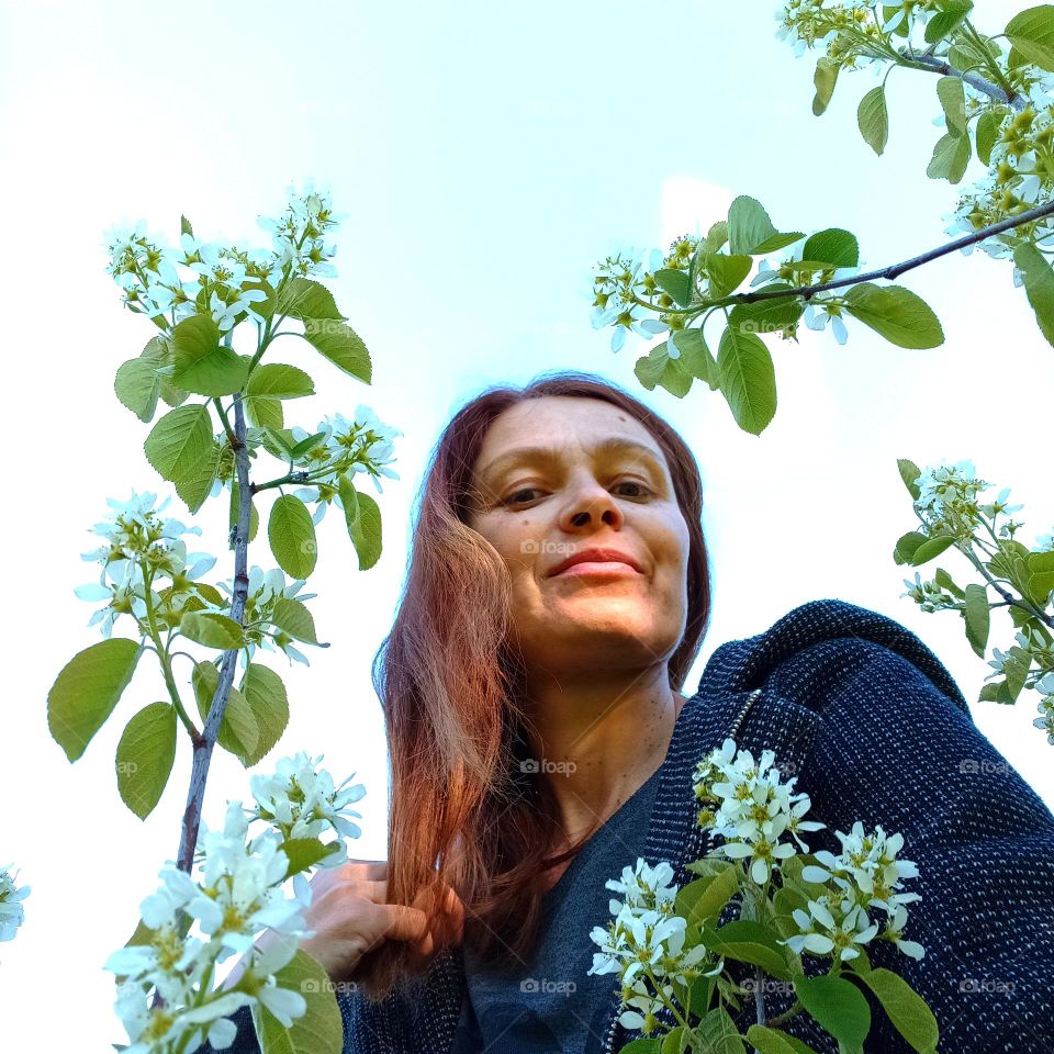 natural woman beautiful portrait with blooming tree white flowers, spring nature, selfie