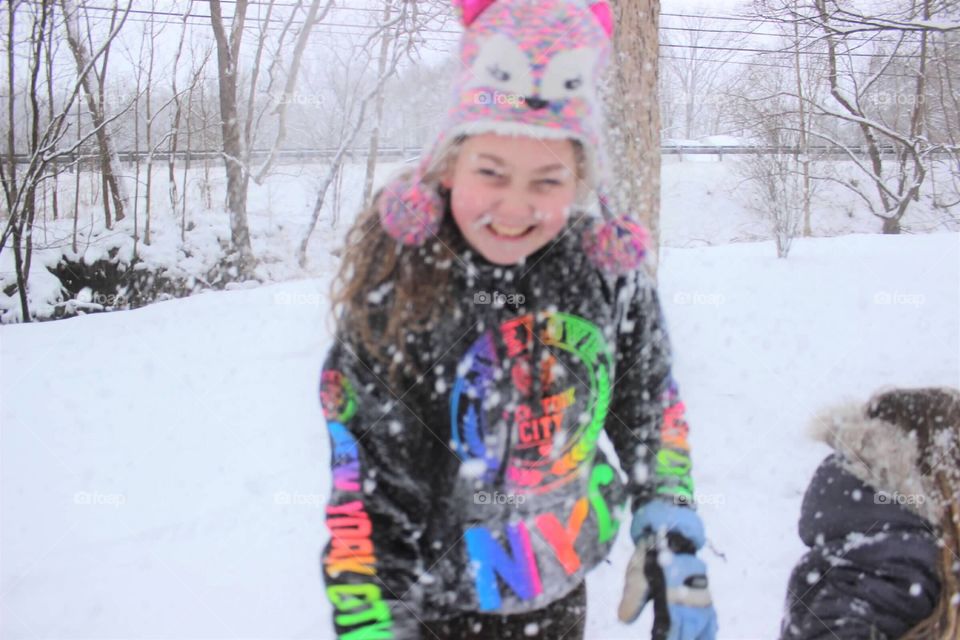The laughter and happiness is written all over her face as she enjoys playing in the snow. 