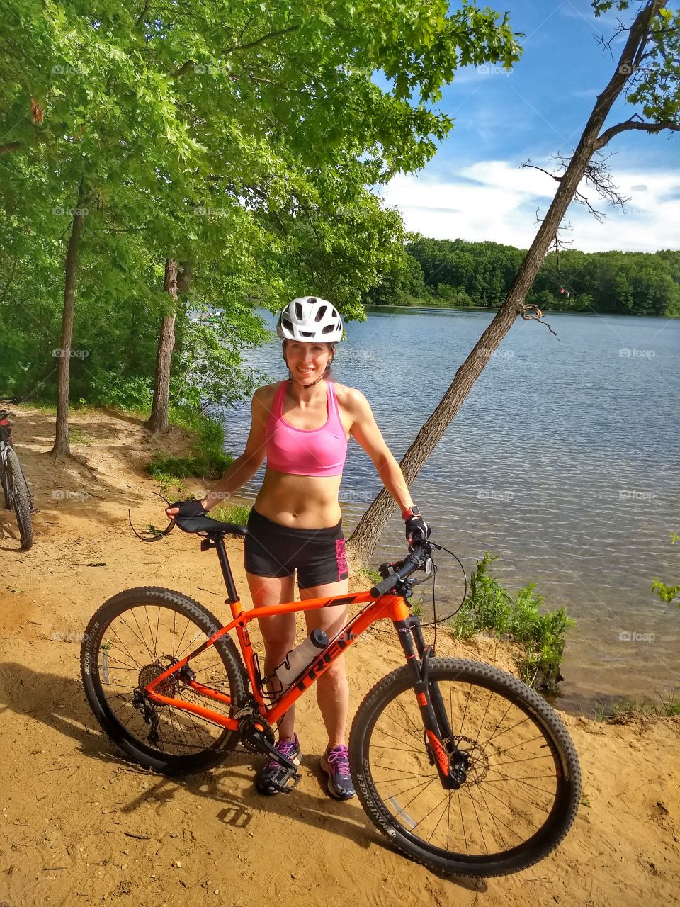 Beautiful woman bikes by beautiful lake