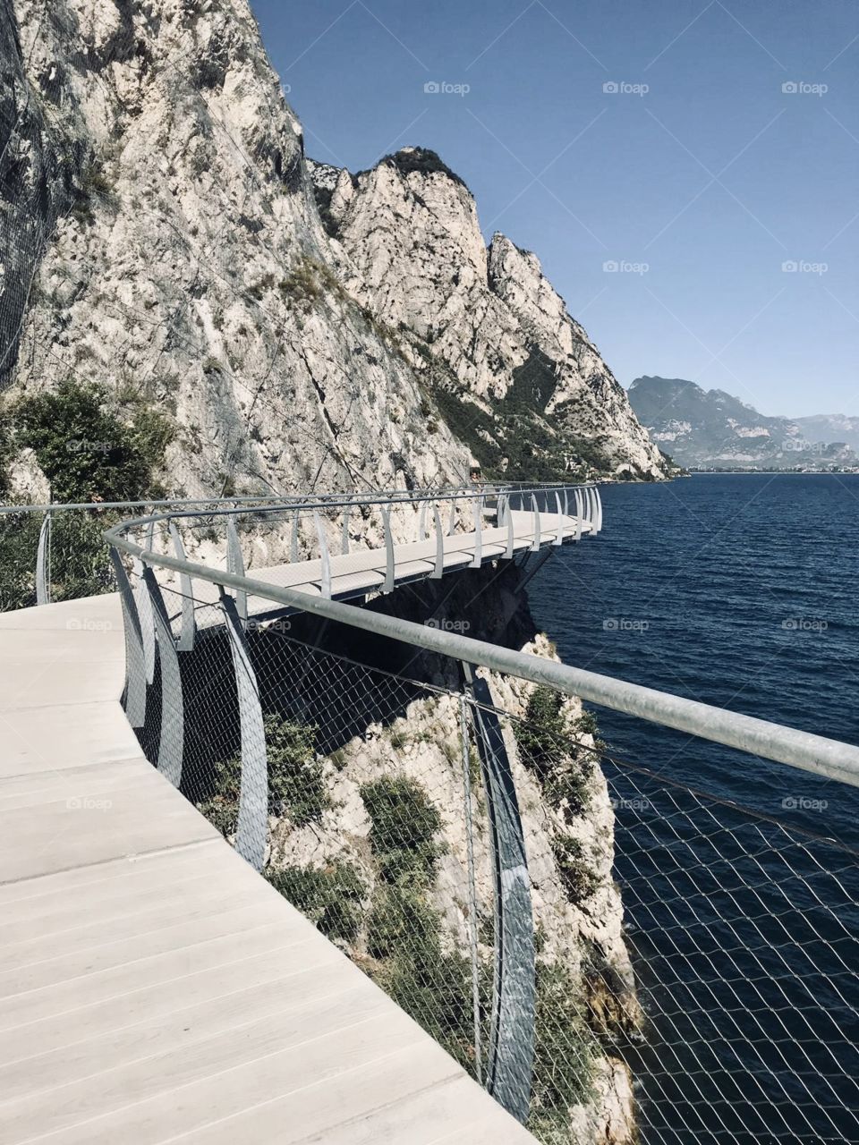 Panoramic bridge just on the cliff of the mountains, starting from Limone sul Garda and heading to Riva del Garda. Limone sul Grada, Lombardia, North Italy. Garda Lake. 