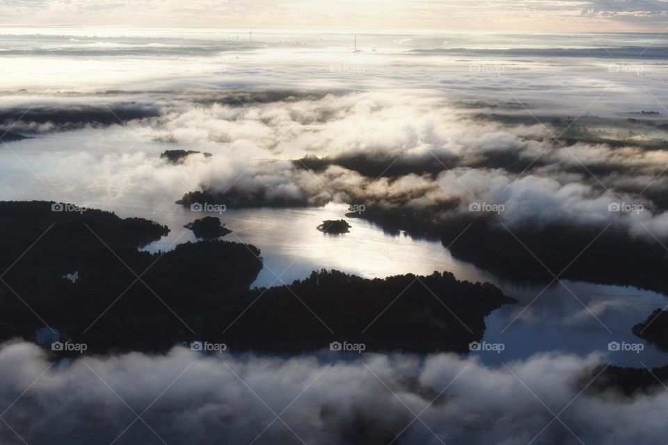 Sunrays shining onto a river and clouds creating a peaceful, dreamy atmosphere.