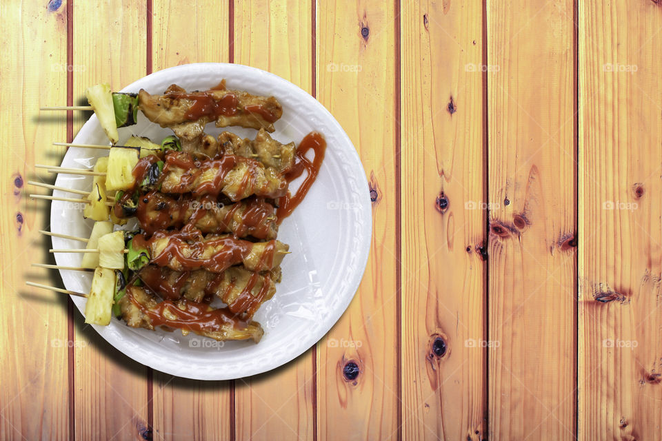 BBQ grilled Chicken with vegetables and tomato sauces on wooden table.