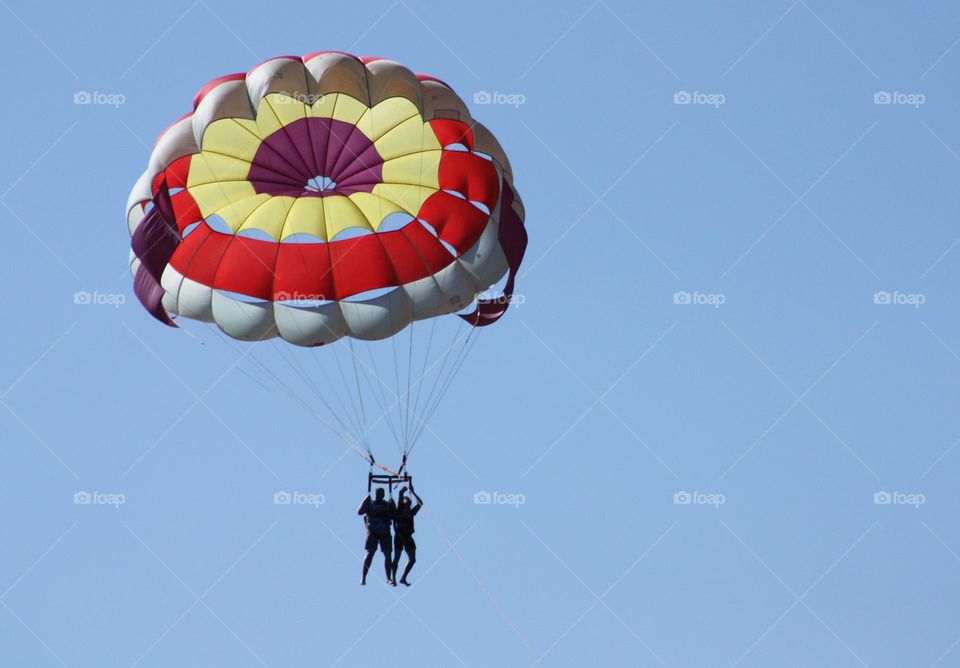 colorful circular paragliding scute in the bright blue sky.