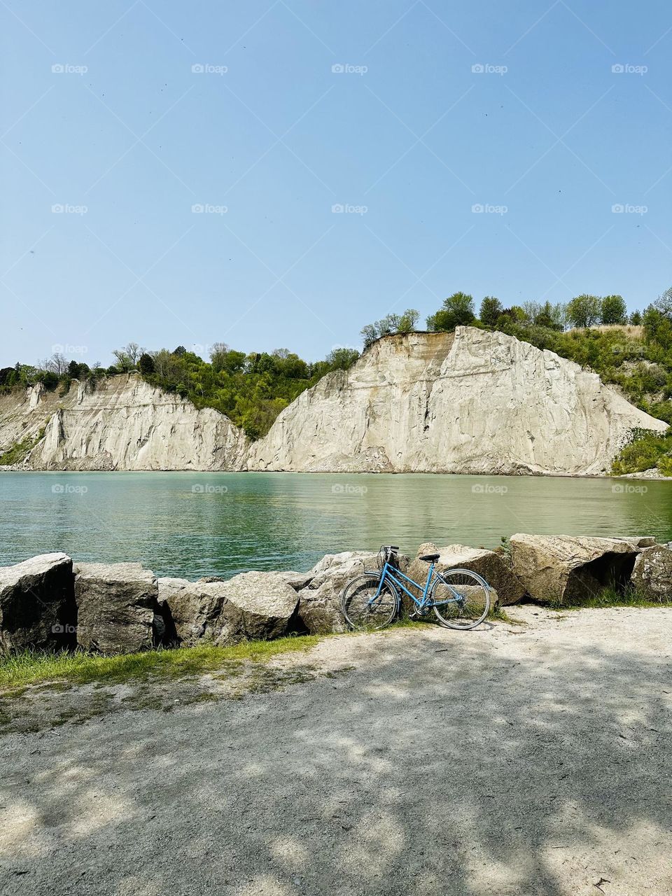 Lonely bicycle, bike standing near beautiful green Lake Ontario in sunny spring day.