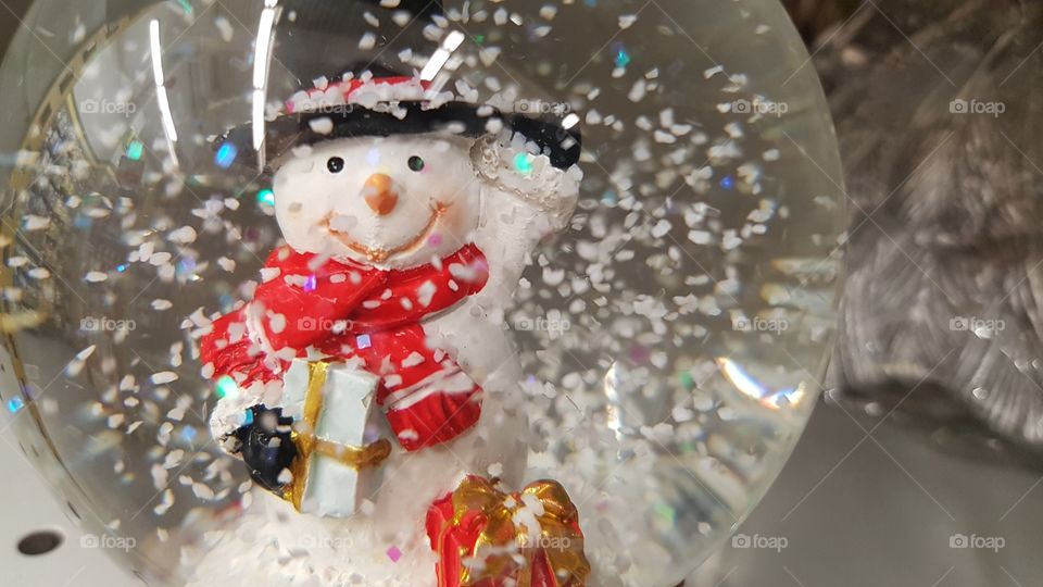 Merry snowman waywing from the snowglobe