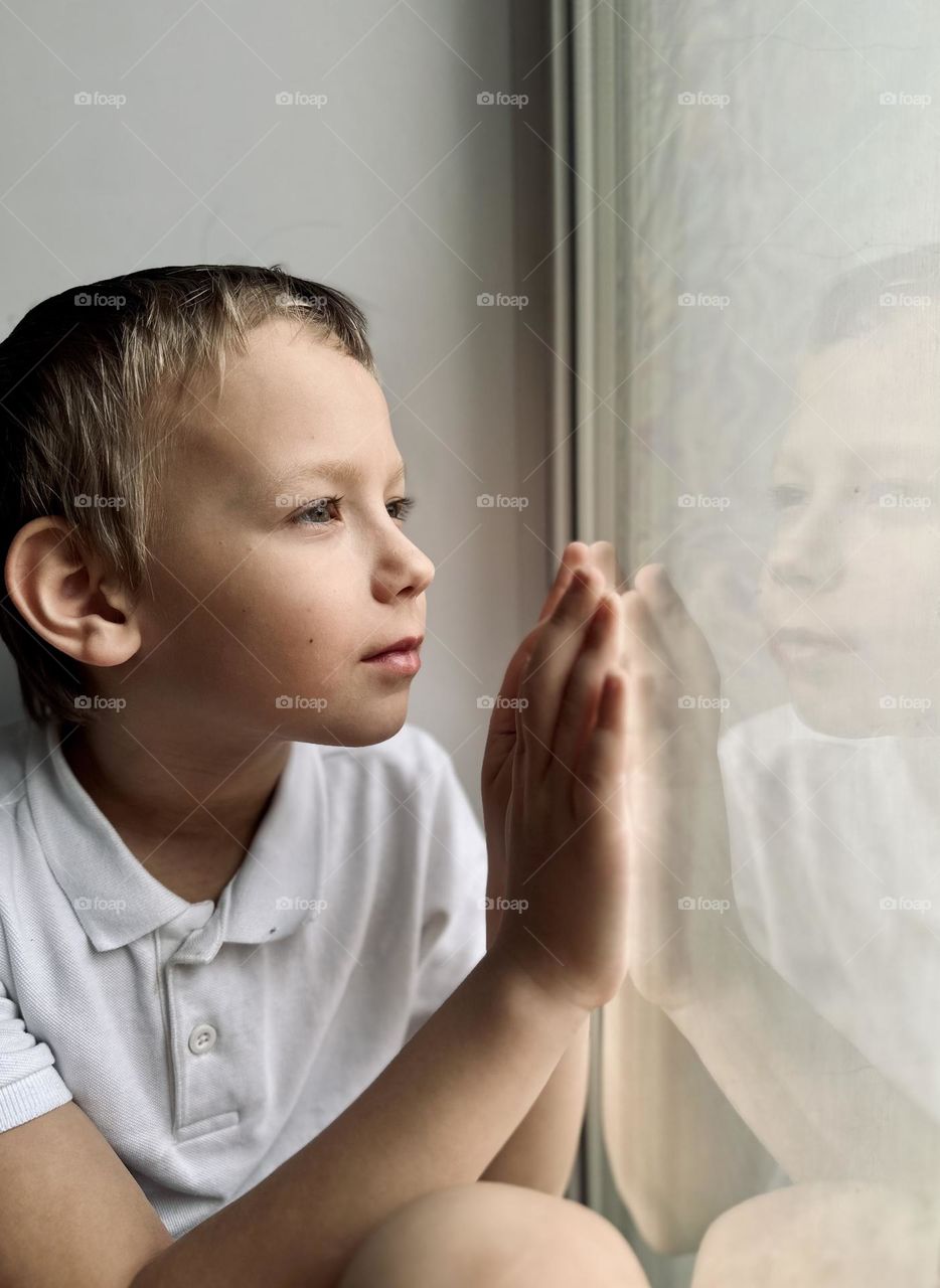 Portrait of a child looking out the window