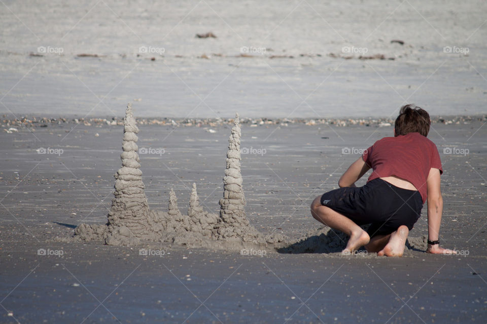 Boy building a sand castle on the beach