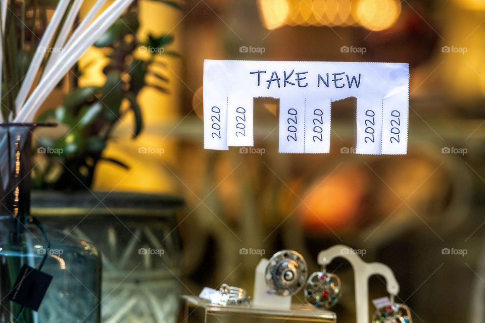 Christmas shop window with paper with the phrase: Take New and with a 2020 sign ready to be tore off