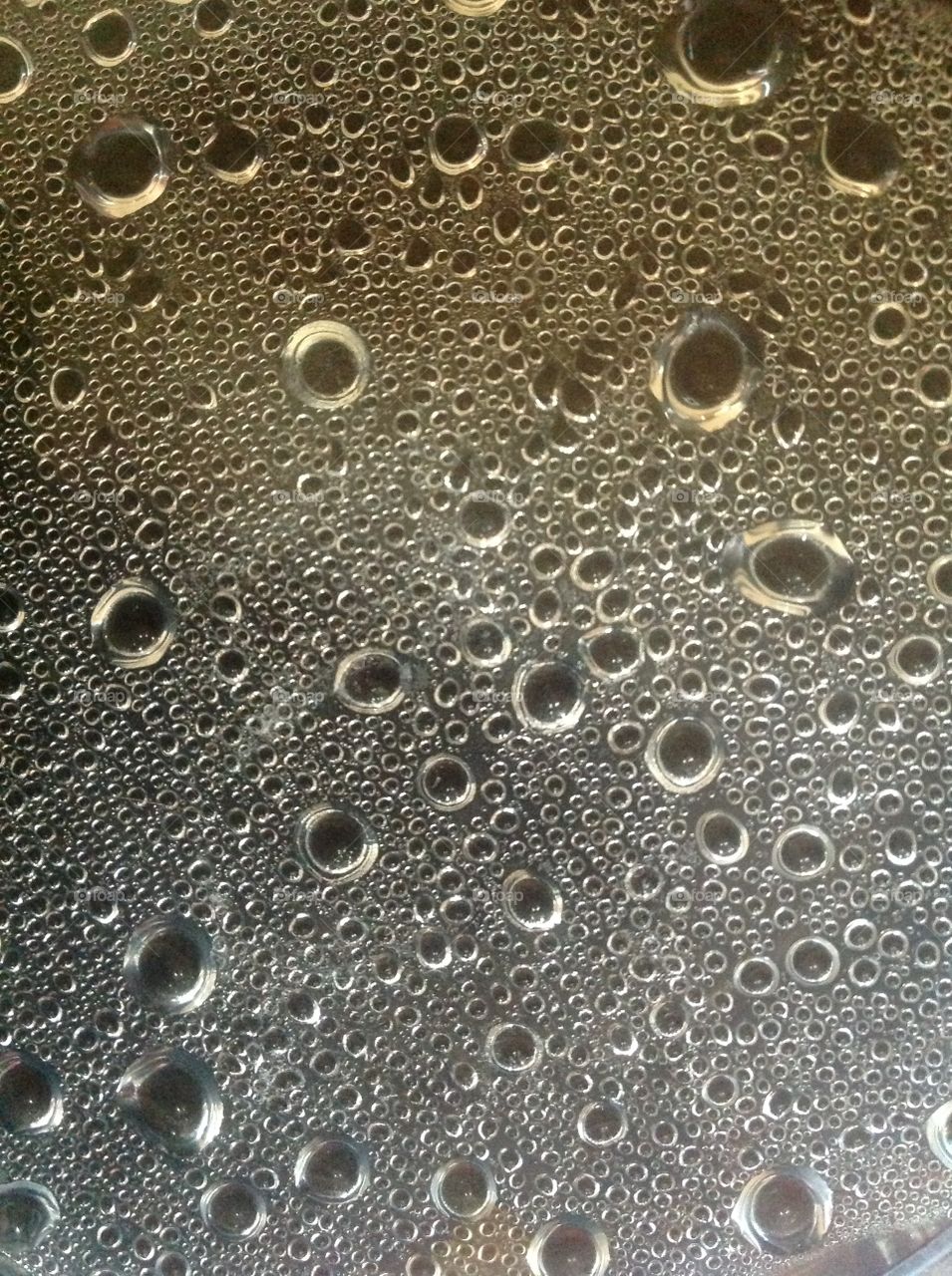 Beautiful pattern formation created by droplets from condensation of water vapor on lid of container.