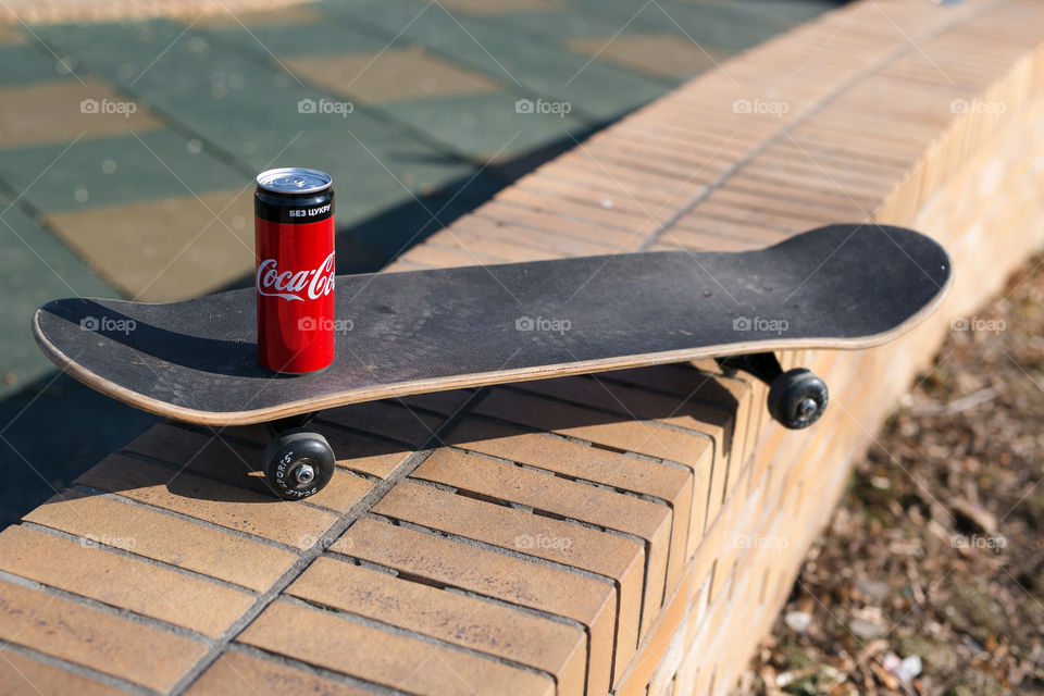 Tasty Coca-Cola, sporty day, spring mood. Kids play at the street 