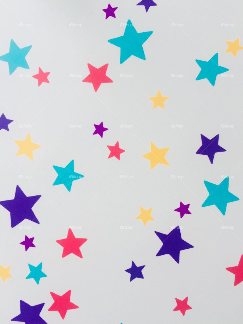 Lots of colourful stars different sizes bundled together on a white piece of paper