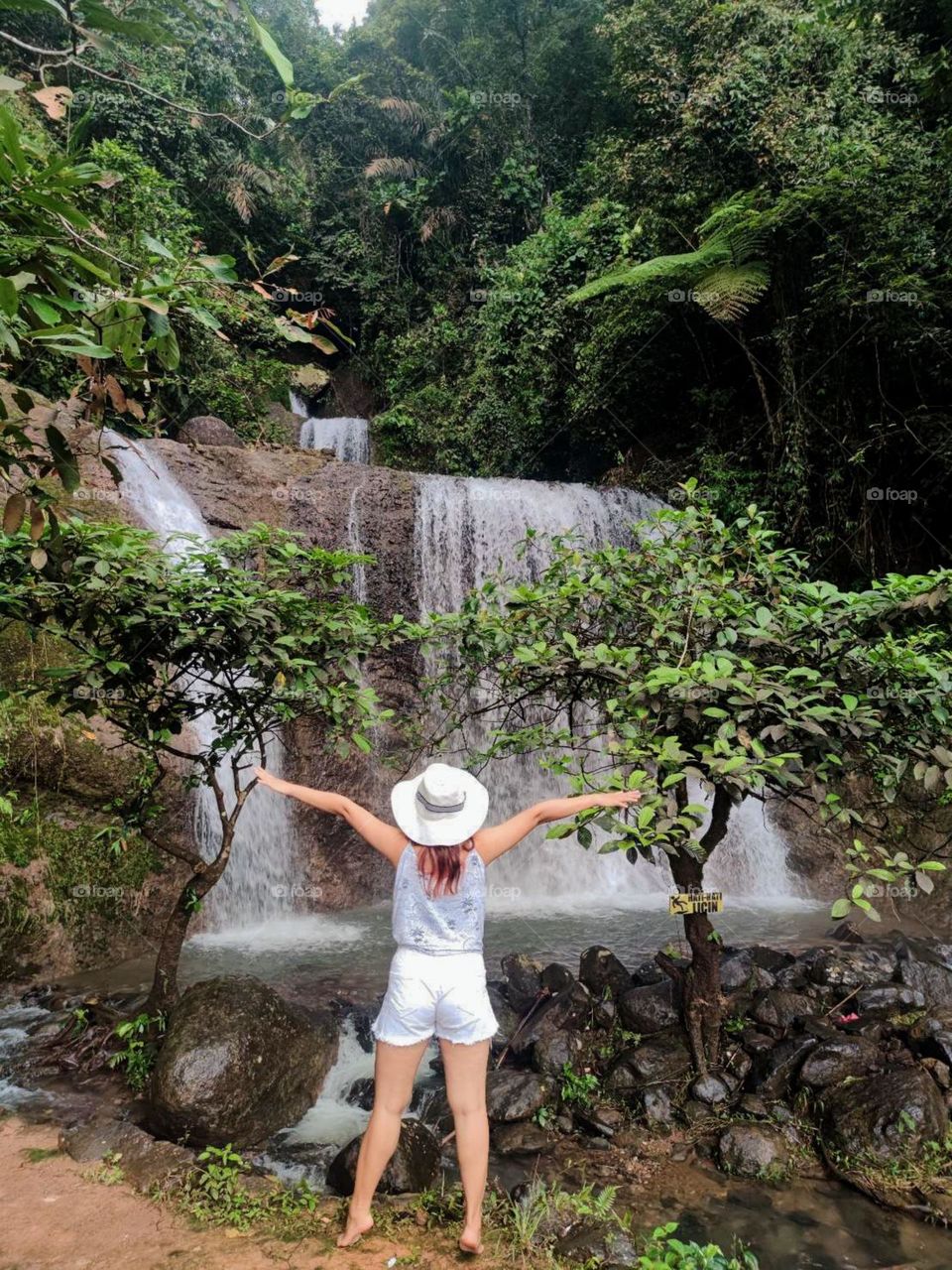 Portrait of woman standing against waterfall