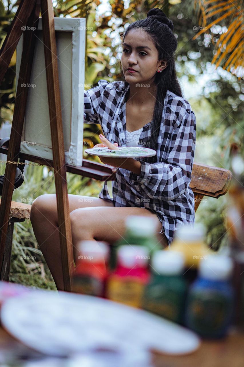 Girl enjoying painting in the middle of nature