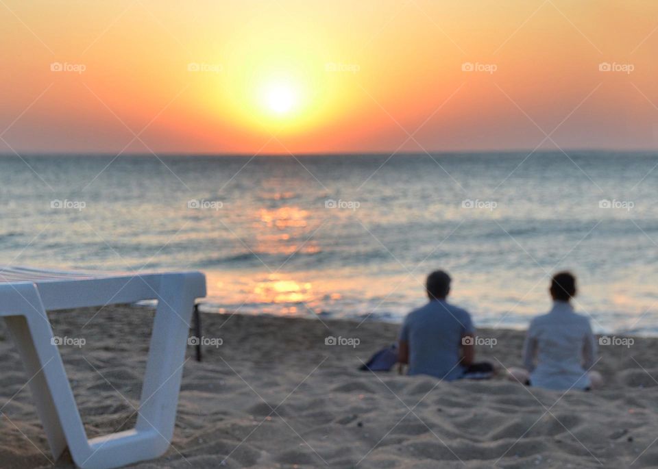 Couple Doing Yoga Outdoor at Sunrise on the Beach