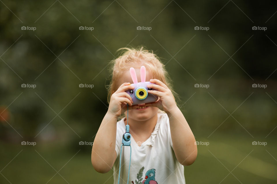 girl with a camera, portrait of a child, fun, hobby, summertime