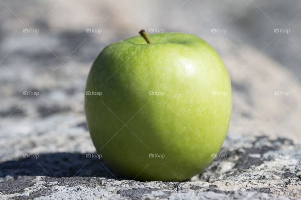 Green apple on the rocks