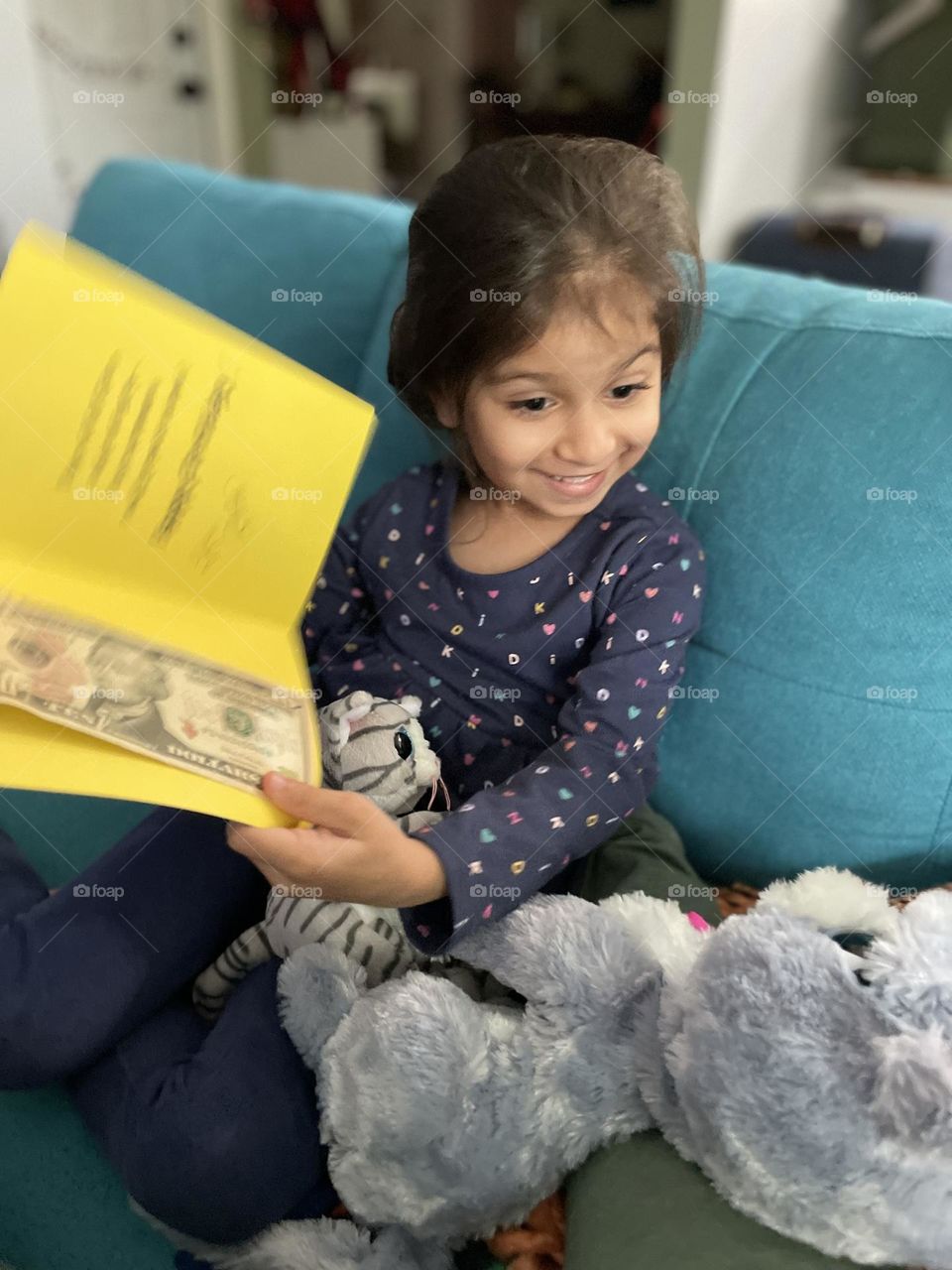 Little girl is very excited to receive a birthday card and money, little girls face shows expression of surprise